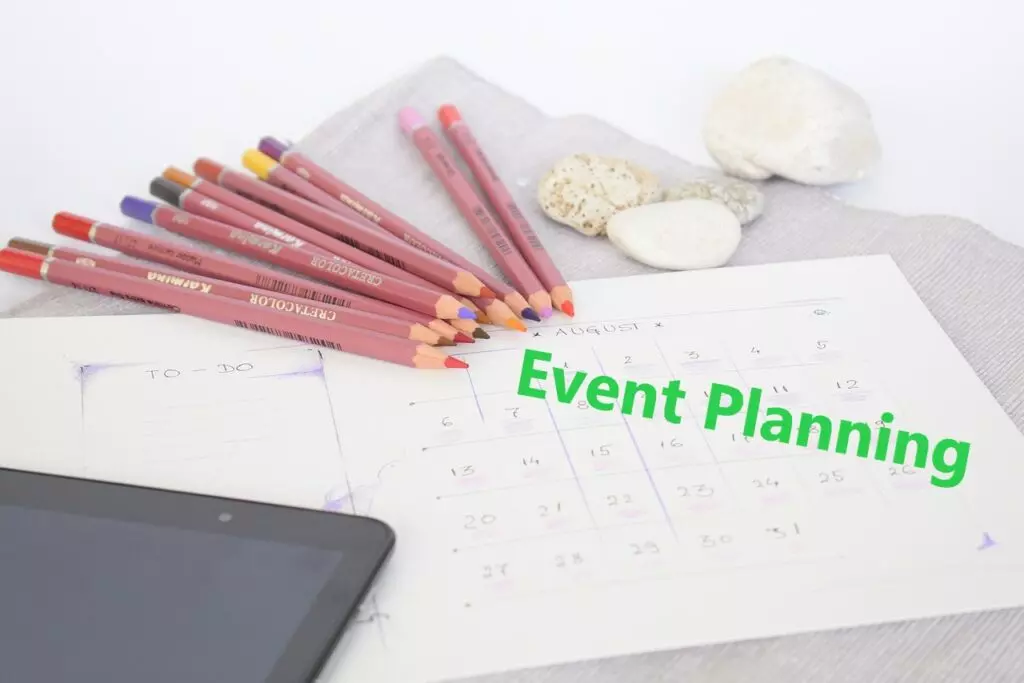 Rozvrh s pastelkami, tabletem a nápisem Event Planning (organizace akcí)